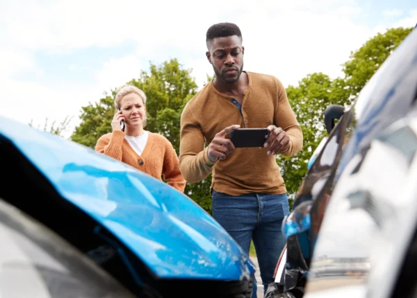 Man taking a photo of a car wreck